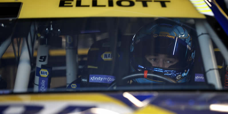 Chase Elliott sits in his car in the garage