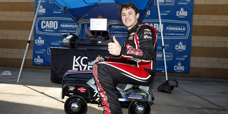 Chase Purdy poses for photos on a toy car after winning the pole award
