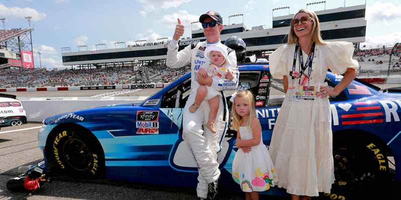 Dale Earnhardt Jr. gives a thumbs up as he spends time with his wife on the grid