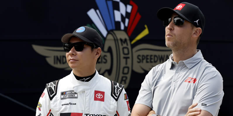 Kamui Kobayashi and 23XI Racing co-owner, Denny Hamlinmeet in the garage area during qualifying