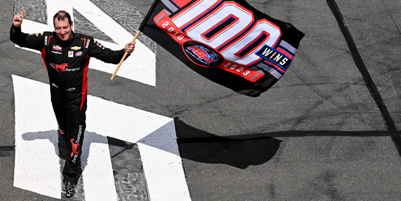 Kyle Busch waves a flag in celebration of Kyle Busch Motorsports' 100th win