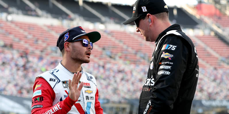 Kyle Larson and Kyle Busch talk on the grid during qualifying