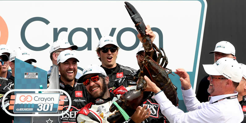 Martin Truex Jr is presented Loudon the Lobster in victory lane