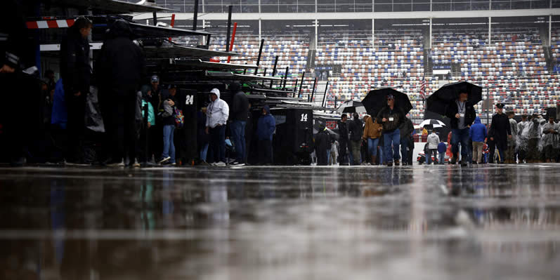 Fans walk through the garage area as it rains