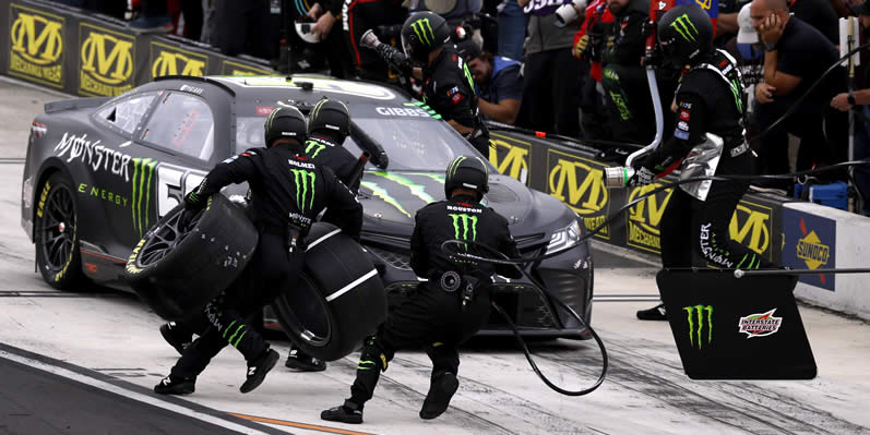 Pit crew members of the #54 Monster Energy Toyota, leaps into action