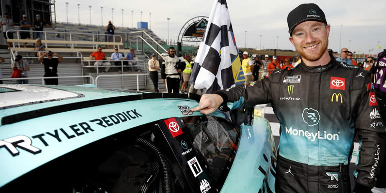 Tyler Reddick poses next to the winner sticker on his car