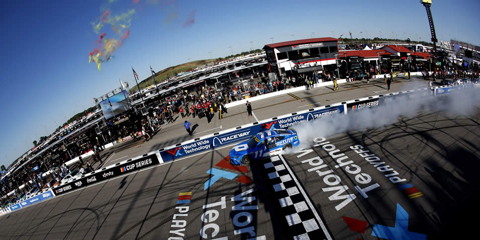Denny Hamlin celebrates with a burnout after winning the Enjoy Illinois 300