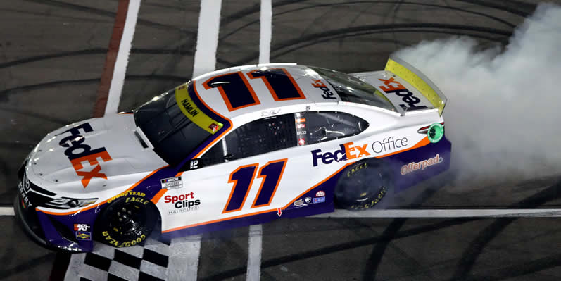 Denny Hamlin celebrates with a burnout after winning