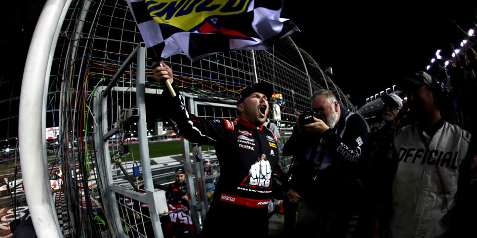 Layne Riggs celebrates with the checkered flag after winning the Ecosave 200