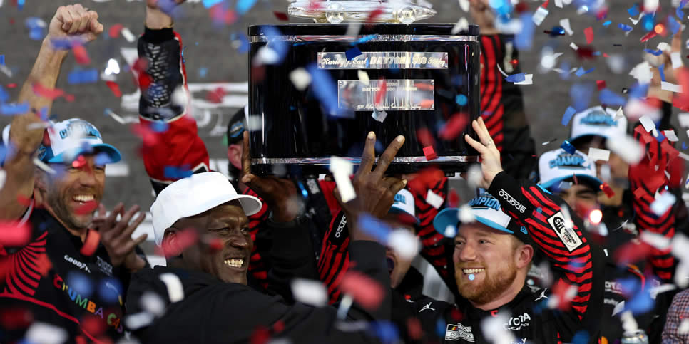 Tyler Reddick and Michael Jordan lift the Harley J. Earl Trophy in victory lane