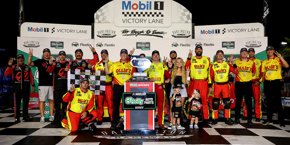 Sheldon Creed celebrates with crew a family in victory lane after winning the Fleetio 200